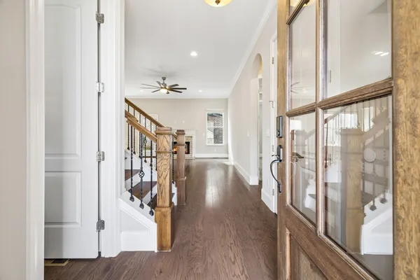 a view of a hallway with wooden floor and staircase