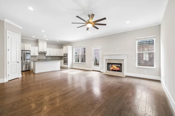 a view of a kitchen with a sink a refrigerator and a fireplace