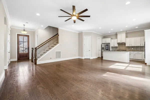 a view of a kitchen with wooden floor and a ceiling fan