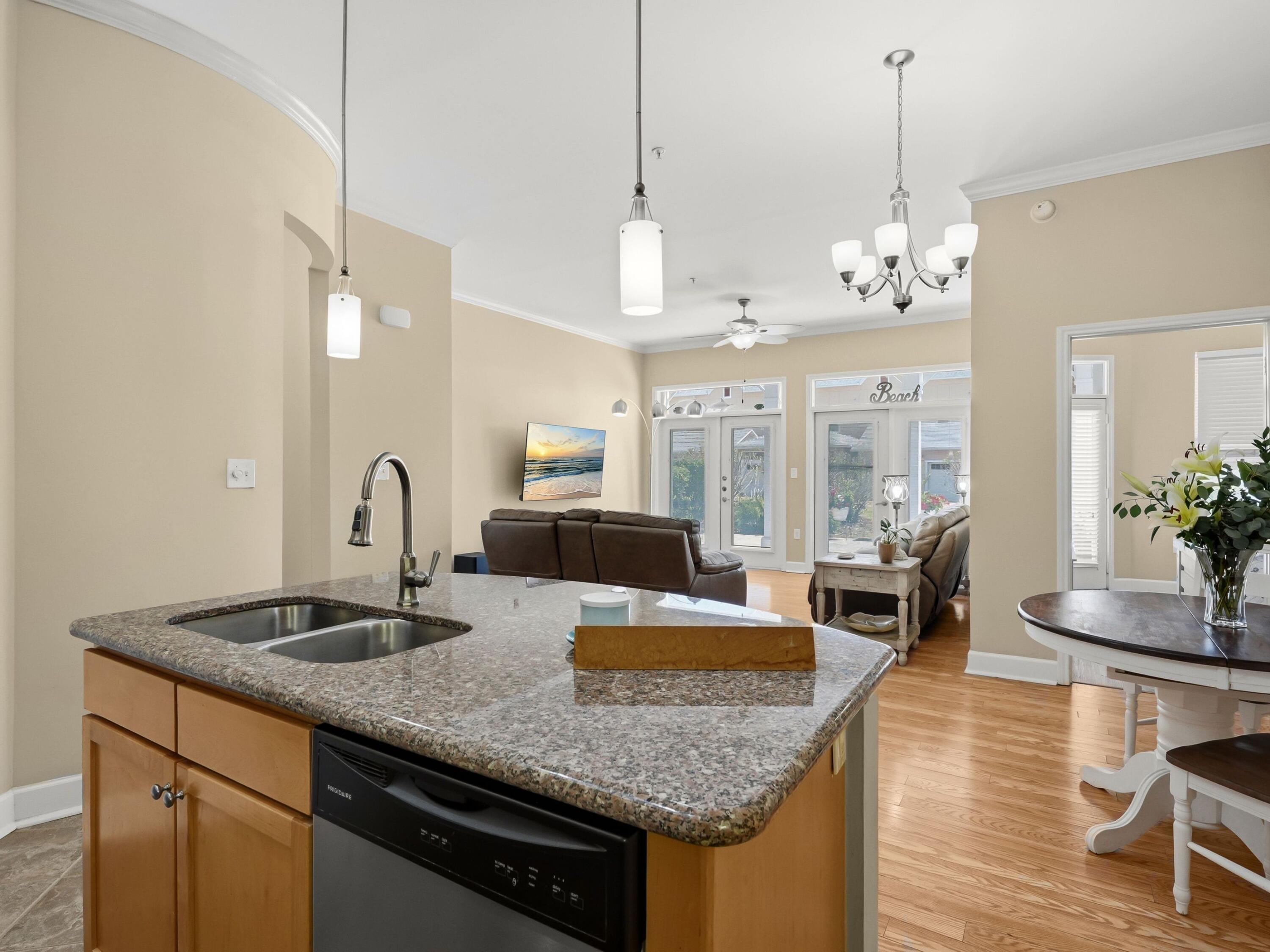 8700 Front Beach Road, Unit 7107 Panama City Beach, FL 32407 - Photo 16 of 54 a kitchen with granite countertop kitchen island stainless steel appliances a sink stove and living room view