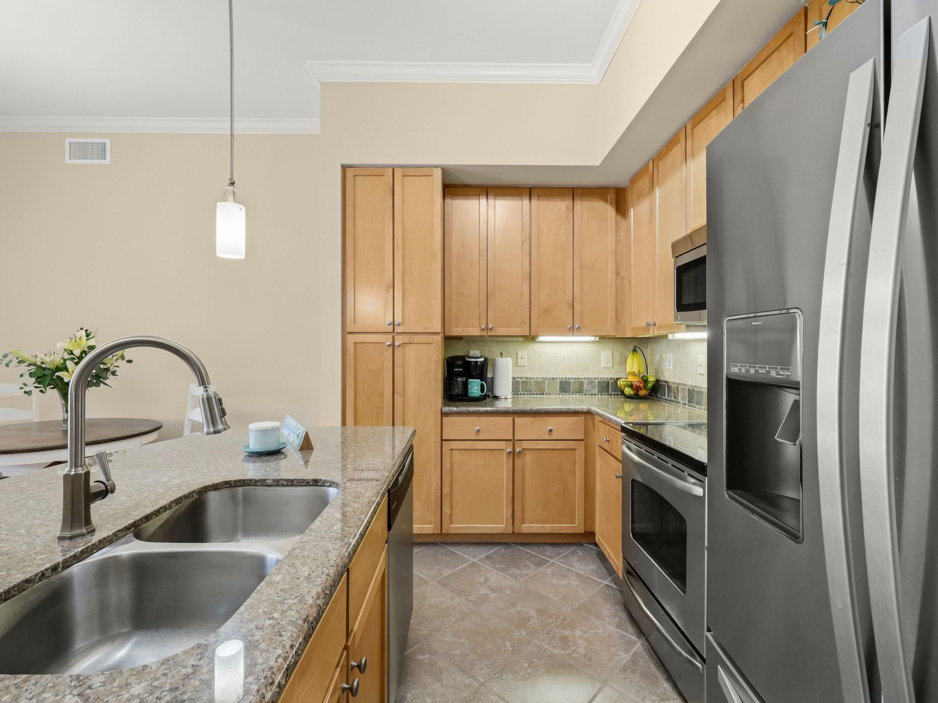 8700 Front Beach Road, Unit 7107 Panama City Beach, FL 32407 - Photo 18 of 54 a kitchen with kitchen island granite countertop a sink stainless steel appliances and cabinets