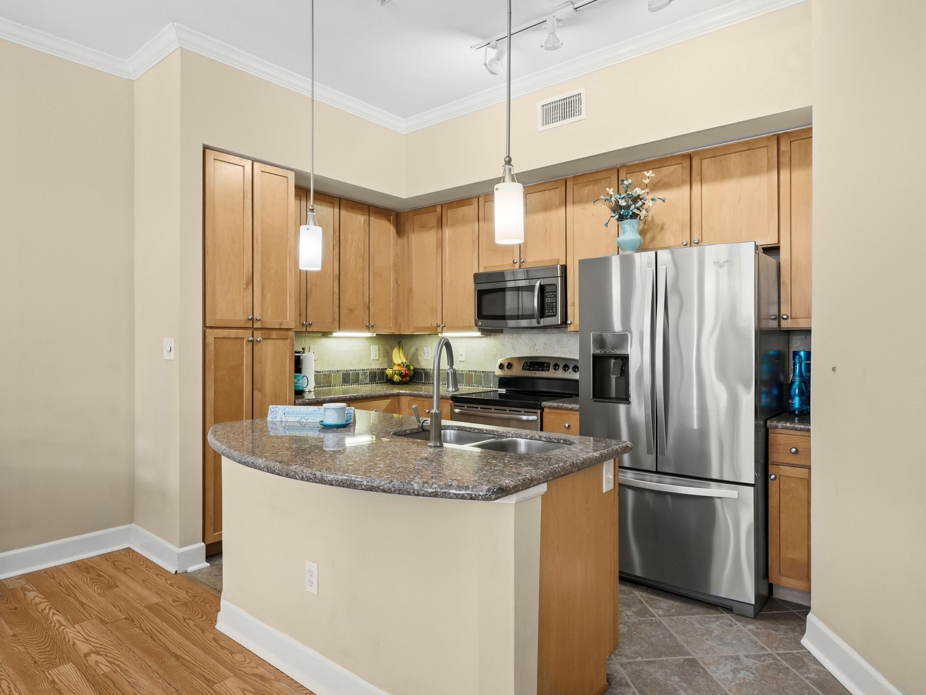 8700 Front Beach Road, Unit 7107 Panama City Beach, FL 32407 - Photo 19 of 54 a kitchen with stainless steel appliances granite countertop a refrigerator a sink and a stove