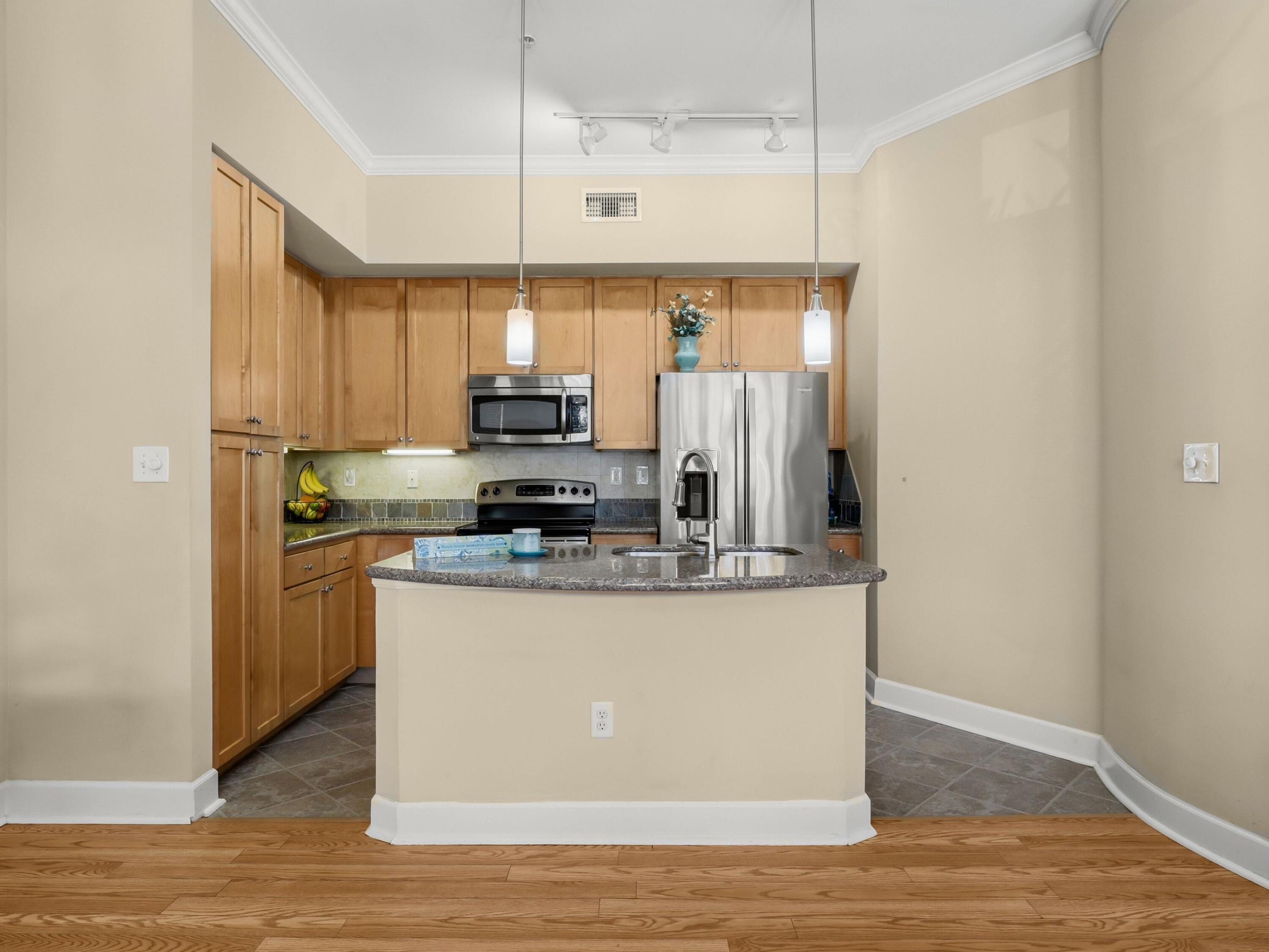 8700 Front Beach Road, Unit 7107 Panama City Beach, FL 32407 - Photo 20 of 54 a kitchen with stainless steel appliances a refrigerator a stove a sink and white cabinets