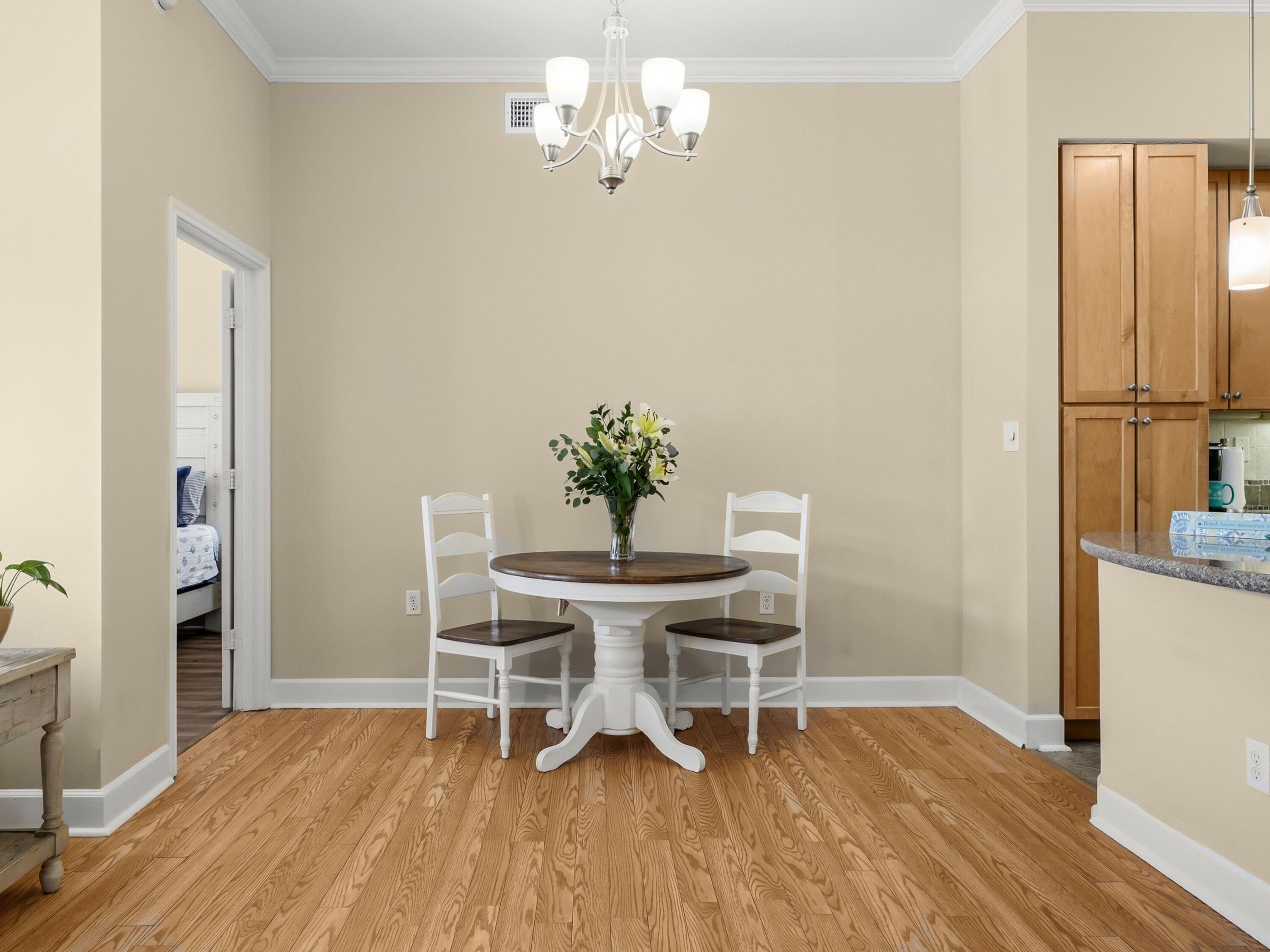 8700 Front Beach Road, Unit 7107 Panama City Beach, FL 32407 - Photo 21 of 54 a view of a dining room with furniture wooden floor and a chandelier