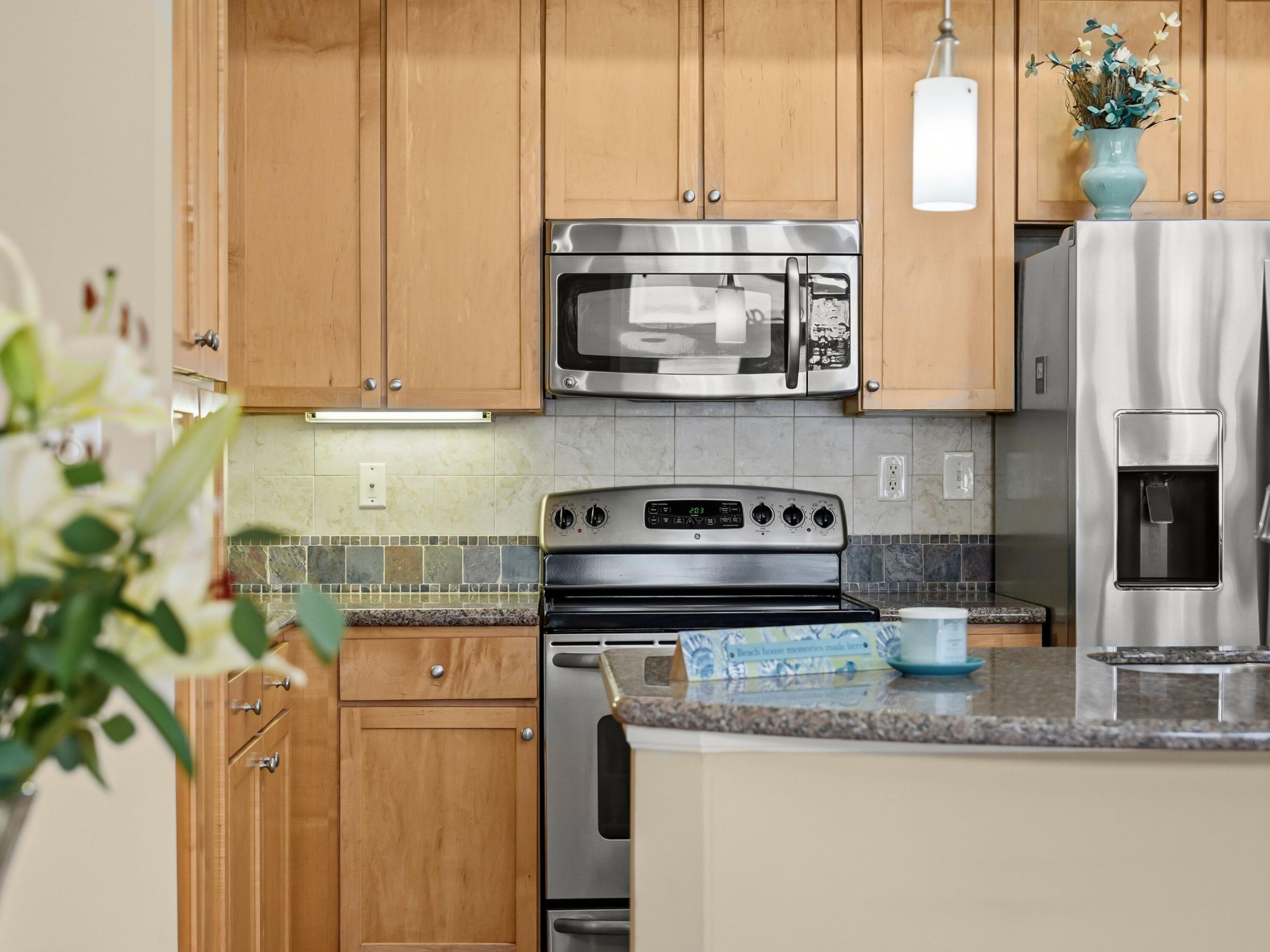 8700 Front Beach Road, Unit 7107 Panama City Beach, FL 32407 - Photo 5 of 54 a kitchen with stainless steel appliances granite countertop a sink a stove and a microwave
