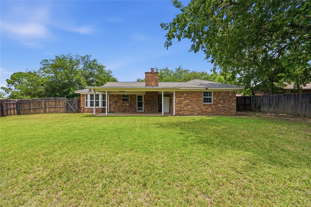 837 Springdale Road Bedford, TX 76021 - Photo 24 of 28 Expansive lawn featuring a privacy fence and mature trees