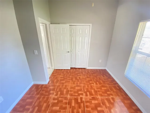 a bedroom with a bed and hardwood floor