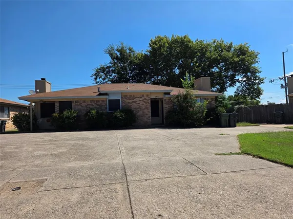 a house with yard and trees in the background