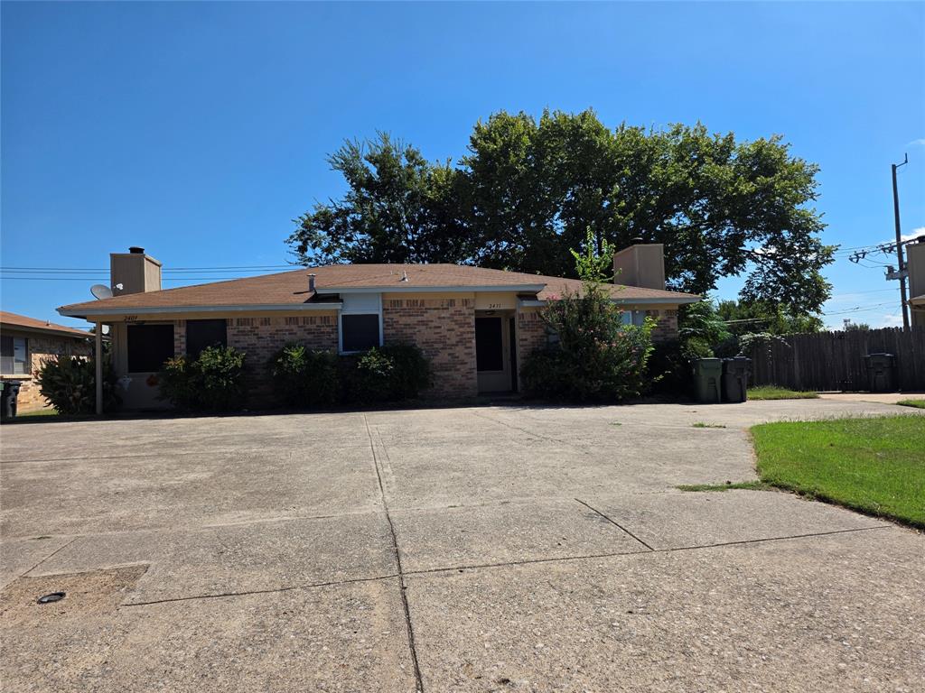 a house with yard and trees in the background