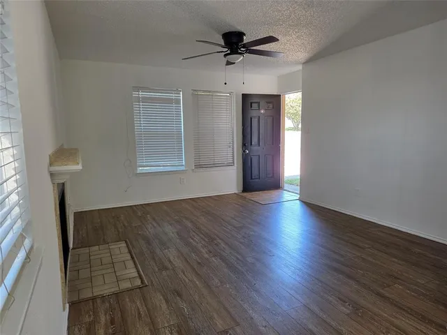 a view of empty room with wooden floor and fireplace