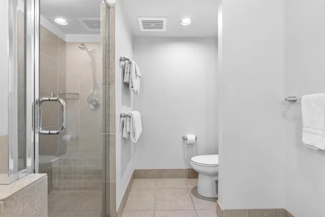 a bathroom with a granite countertop shower and a toilet