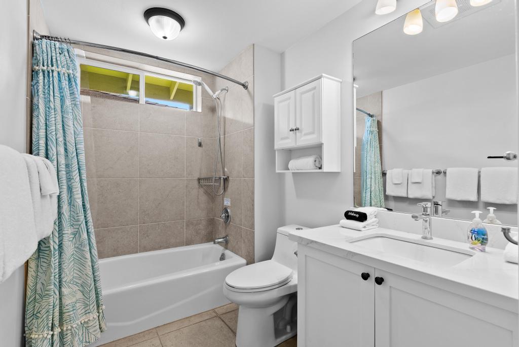 69-1033 Nawahine Place, Unit 22H Waikoloa, HI 96738 - Photo 17 of 29 a bathroom with a sink a toilet and shower