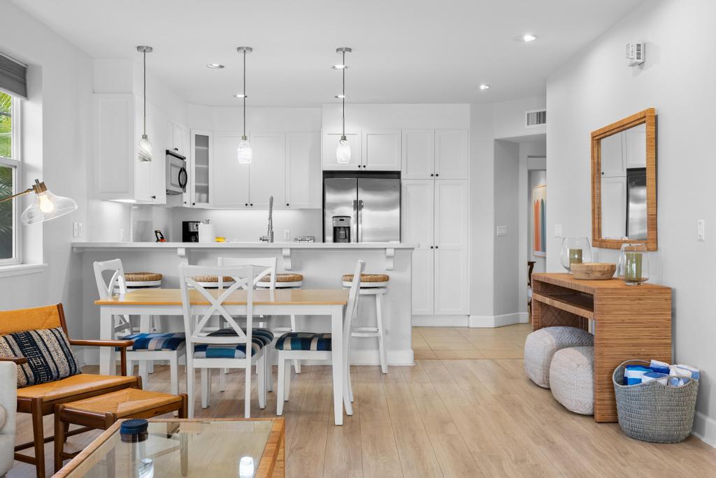 69-1033 Nawahine Place, Unit 22H Waikoloa, HI 96738 - Photo 3 of 29 a dining room with furniture a wooden floor and a chandelier