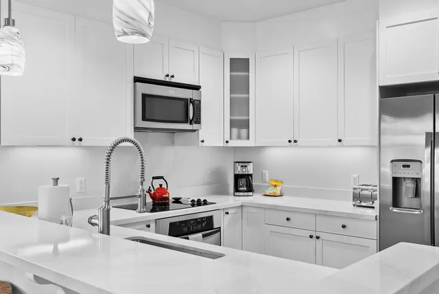 a kitchen with white cabinets and stainless steel appliances