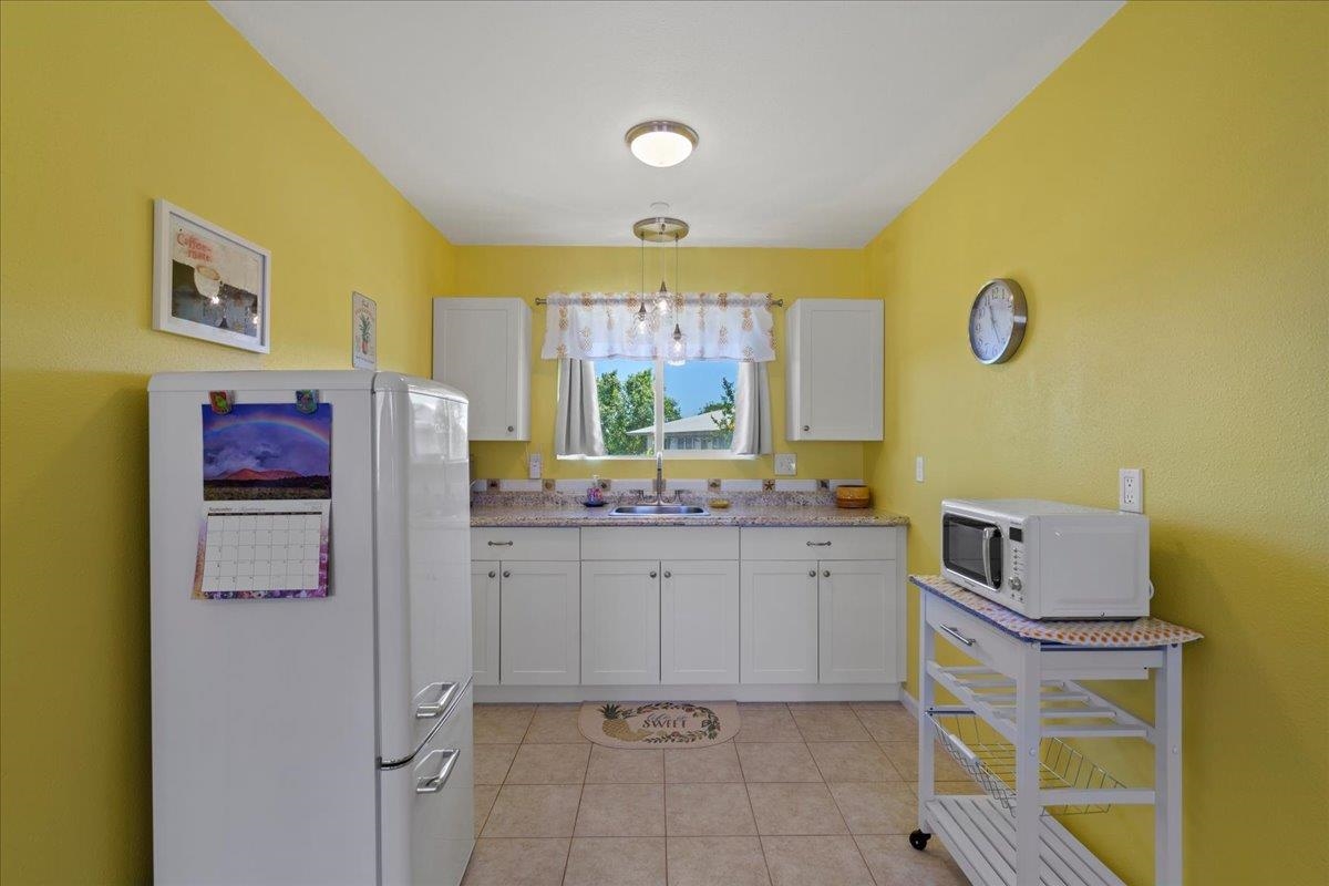 110 Kahiapo Place Haiku, HI 96708 - Photo 28 of 36 a bathroom with a granite countertop sink and a mirror