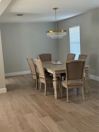 a view of a dining room with furniture wooden floor and chandelier