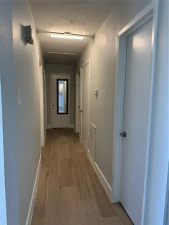 a view of a hallway with wooden floor