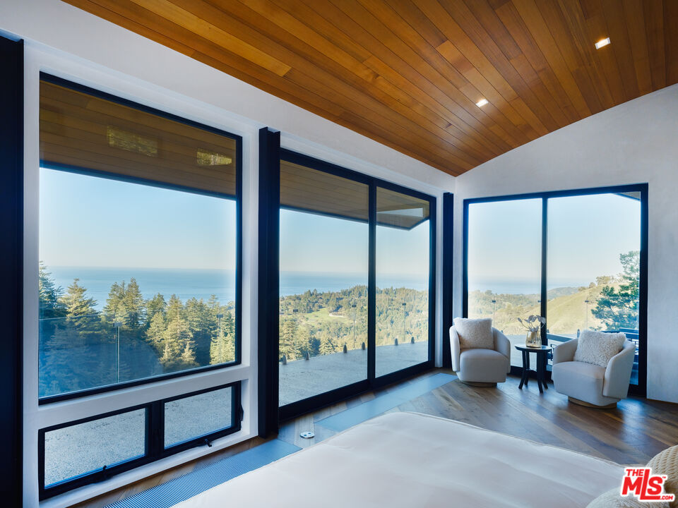 47730 Coast Ridge Road Big Sur, CA 93920 - Photo 17 of 37 a living room with furniture and large windows