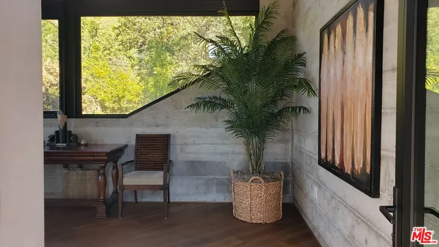 a porch with a bench and potted plants