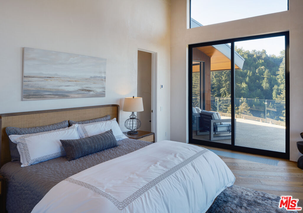 47730 Coast Ridge Road Big Sur, CA 93920 - Photo 20 of 37 a bedroom with a large bed and a large window