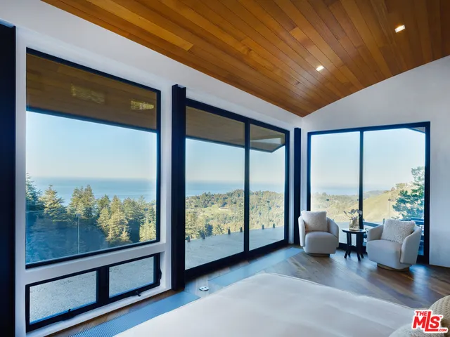 a living room with furniture and large windows