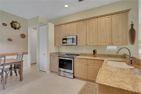 a kitchen with stainless steel appliances granite countertop a stove a sink and a refrigerator
