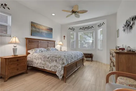 a bedroom with a large bed a flat tv screen and dresser