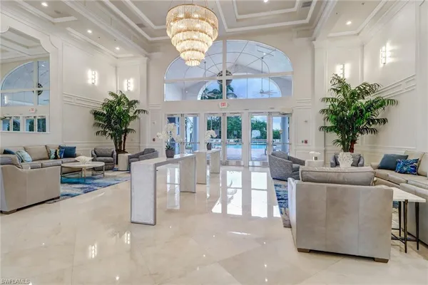 a living room with furniture a chandelier and a large window