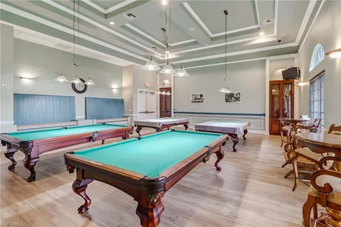 a room with pool table and wooden floor
