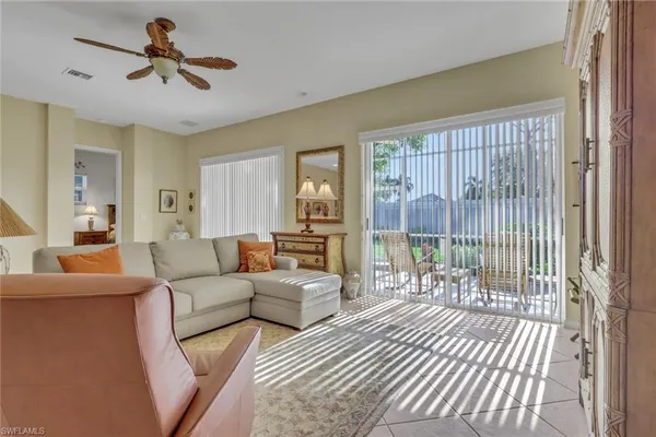 a living room with furniture and a floor to ceiling window