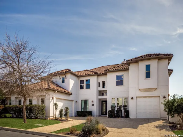 a view of a white house with a big yard and large tree