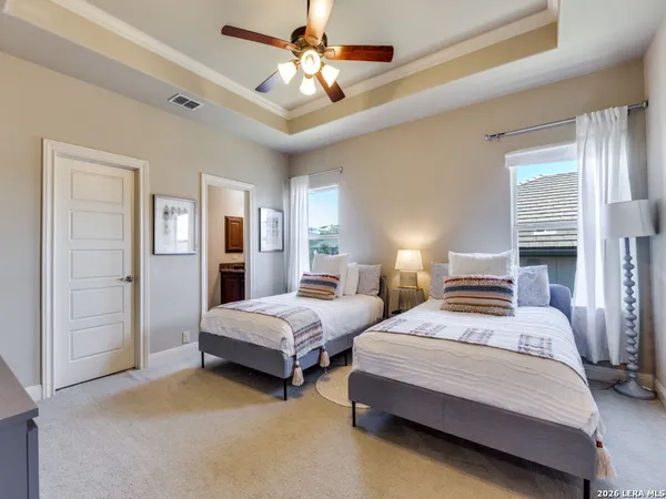 a bedroom with two beds and a chandelier