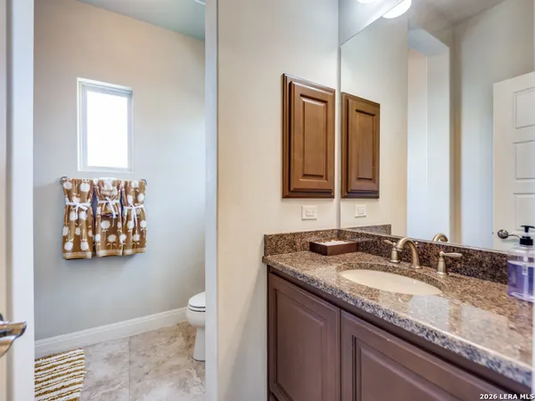 a bathroom with a granite countertop sink and a mirror