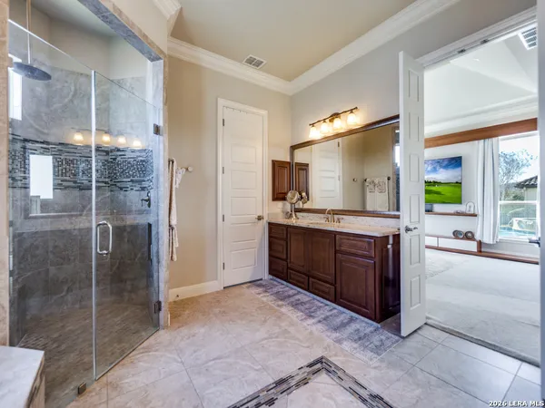 a large bathroom with a glass door shower and sink