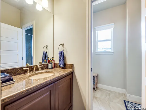 a bathroom with a granite countertop sink and a mirror