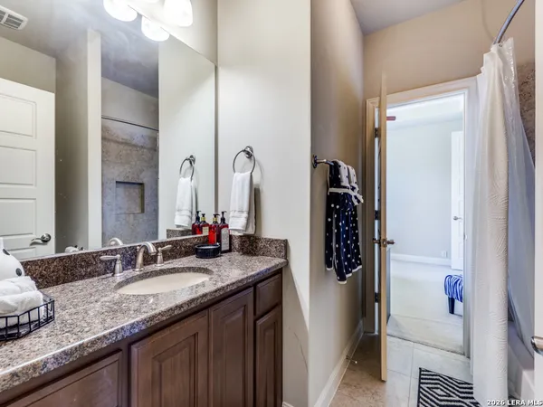 a bathroom with a granite countertop sink and a mirror