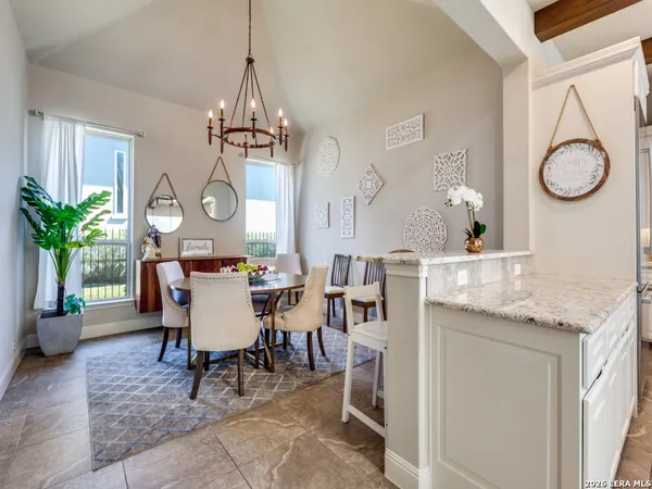 a dining room with wooden floor a chandelier a wooden table and chairs