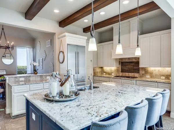 a kitchen with granite countertop a sink a stove and cabinets