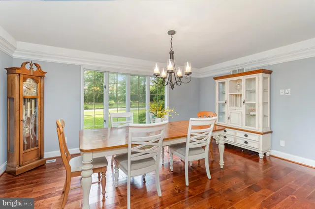 a view of a dining room with furniture a chandelier and wooden floor
