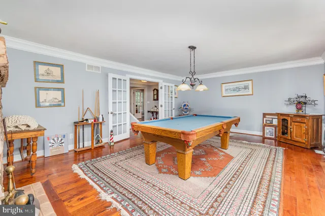 a dining room with furniture a chandelier and wooden floor