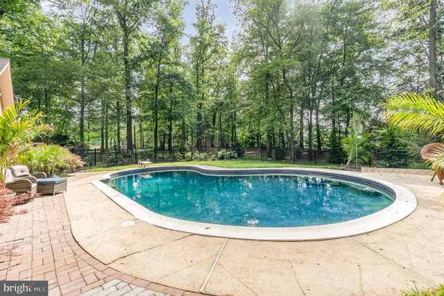 an aerial view of a house with a yard and covered with trees
