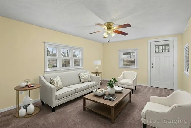 a living room with furniture a rug and a window
