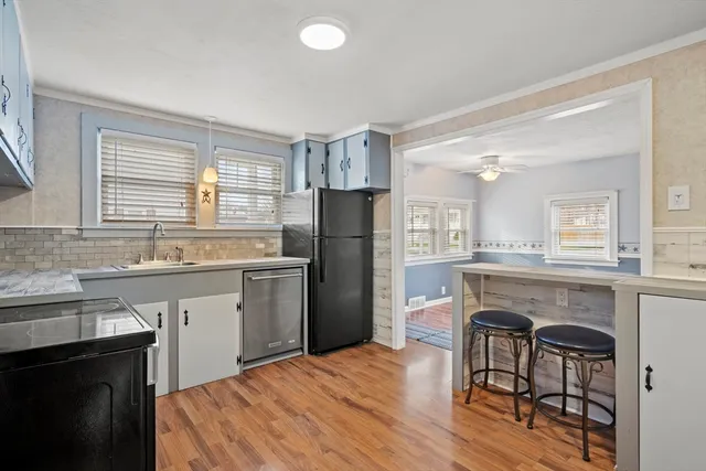 a kitchen with a table chairs refrigerator and microwave