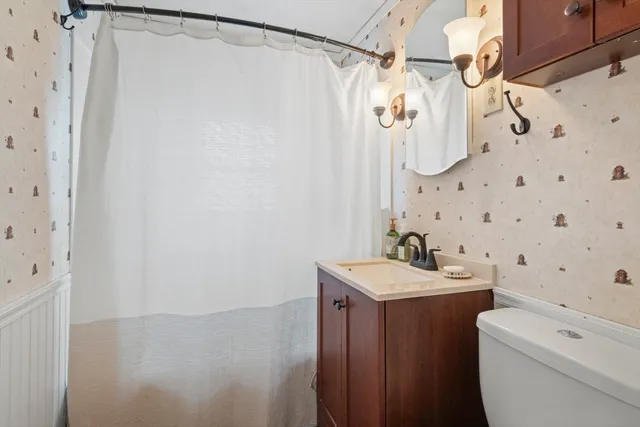 a bathroom with a sink a toilet and shower