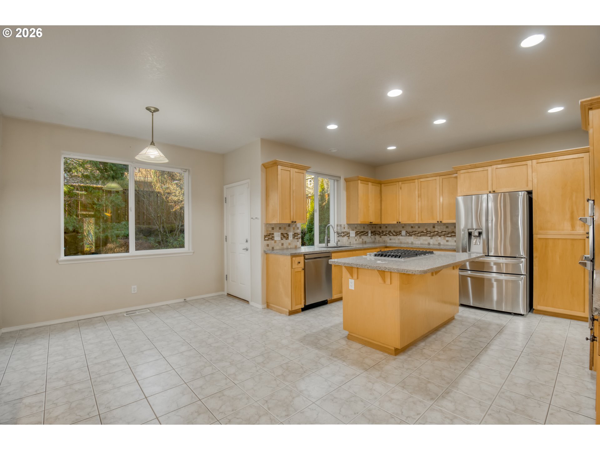 3637 Northwest Lansbrook Terrace Portland, OR 97229 - Photo 11 of 43 a open kitchen with stainless steel appliances granite countertop a refrigerator a sink a stove and oven with wooden floor