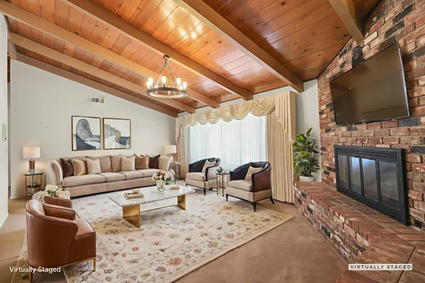 a living room with furniture a flat screen tv and a fireplace