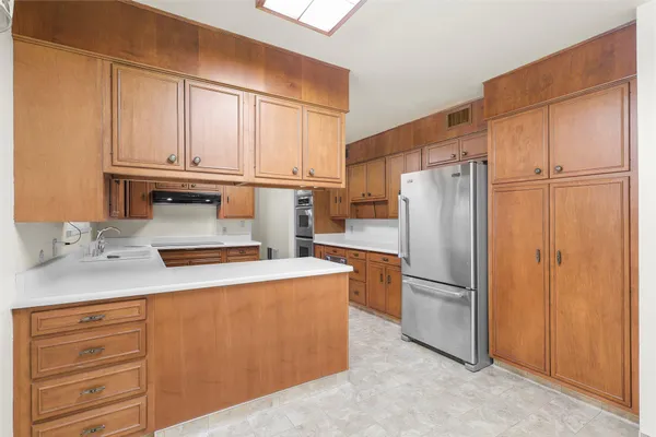 a kitchen with stainless steel appliances granite countertop a refrigerator a sink and cabinets