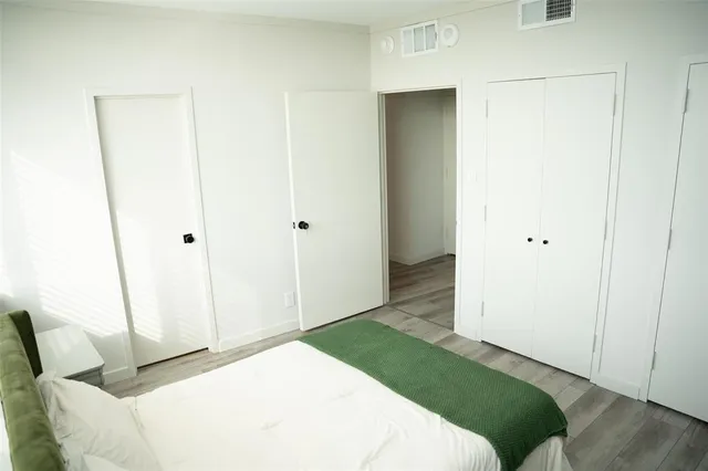 a bedroom with a bed and a white cabinet
