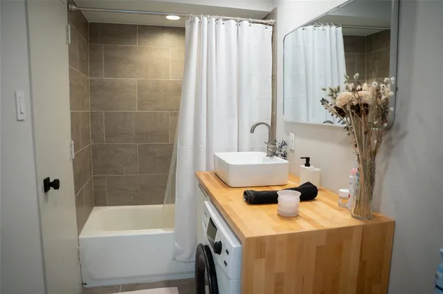 a bathroom with a tub sink and mirror