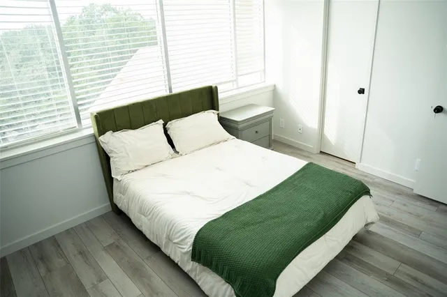 a large bed sitting in a bedroom next to a window